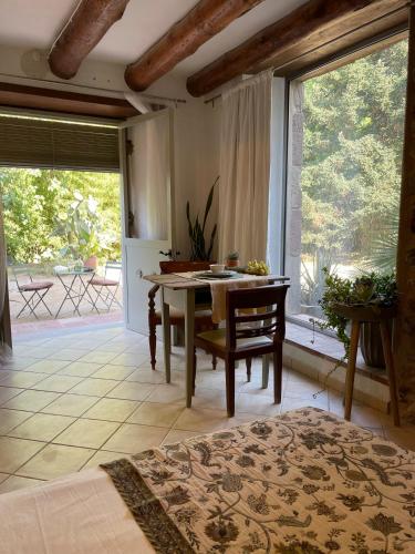 a living room with a table and a large window at Can TABERNER in Bigues i Riells
