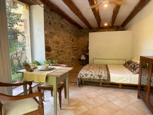 a bedroom with a bed and a table in a room at Can TABERNER in Bigues i Riells