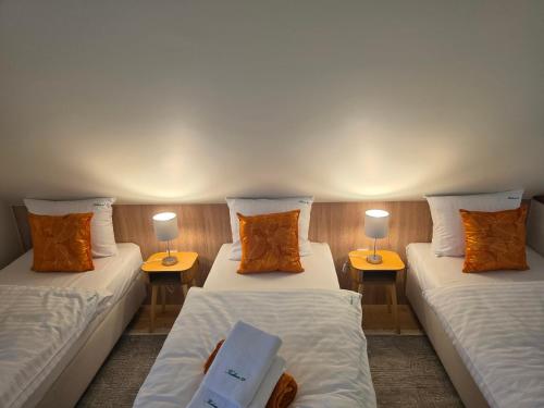 a room with two beds and two tables with lamps at Apartamenty Kukinia33 in Kukinia