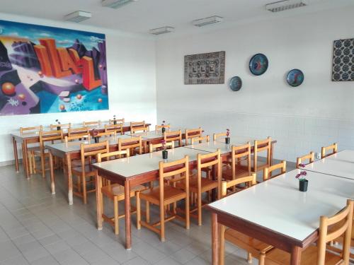 ラゴスにあるHI Lagos - Pousada de Juventudeのダイニングルーム(テーブル、椅子、絵画付)