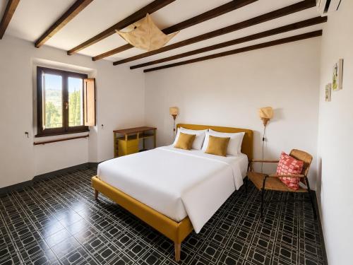 a bedroom with a large white bed and a chair at Medici Villa with Gardens 7 min from Florence in Fiesole