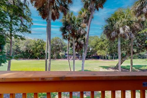 a wooden bench with palm trees in a park at The Tidey Turtle in Edisto Beach