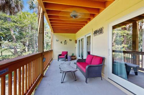 a porch with two chairs and a table at The Tidey Turtle in Edisto Beach