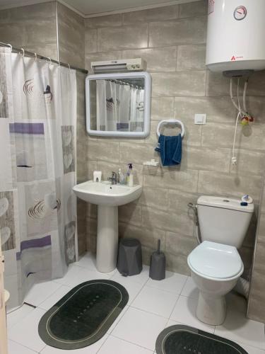 a bathroom with a toilet and a sink and a mirror at T2 vue sur mer in Bejaïa