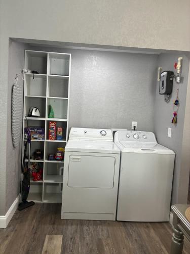 a laundry room with two machines and a shelf at New Haven 5 mi from Legoland in Winter Haven
