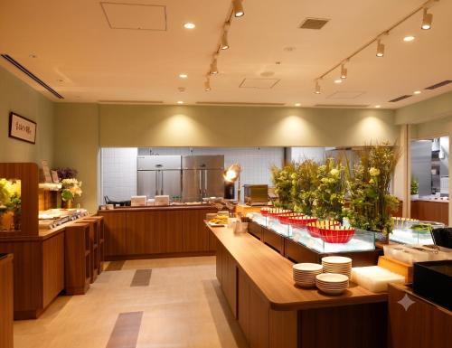 a restaurant with a counter with dishes on it at Dormy Inn Nagano in Nagano