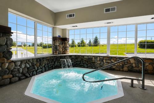 a jacuzzi tub in a room with windows at Microtel Inn & Suites by Wyndham Bozeman in Bozeman