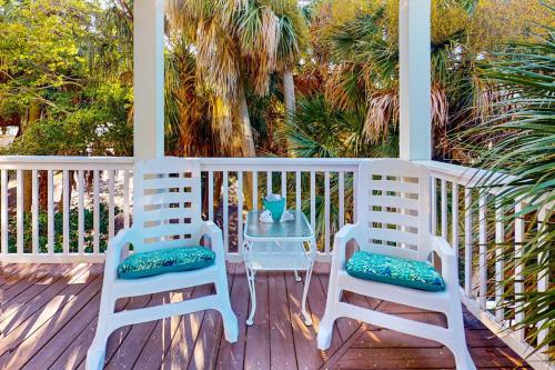 two chairs and a table on a porch at Sea Sea Rider in Edisto Beach