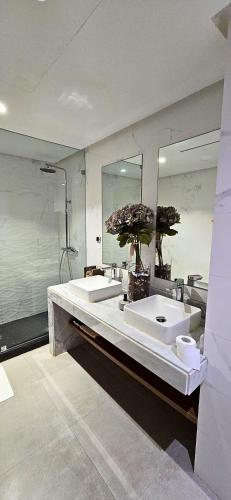 a bathroom with two sinks and a large mirror at Villa Séréna Pool and Comfy in Tamaris