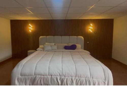 a large white bed in a room with two lights at villa paraíso in Piura