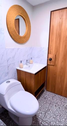 a bathroom with a toilet and a sink and a mirror at villa paraíso in Piura