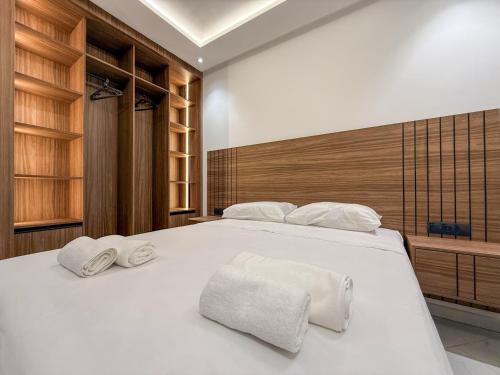 a bedroom with a large white bed with towels on it at LA VILLA Appart in Al Hoceïma
