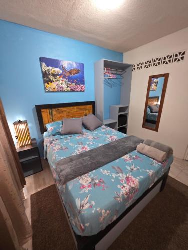 a bedroom with a bed with a blue wall at Gloria's Hideaway in Christ Church