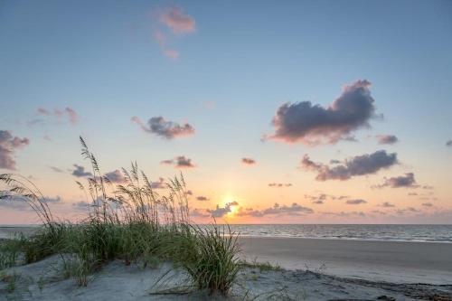 a sunset on the beach with a sandy beach at Xanadu D8 in Hilton Head Island