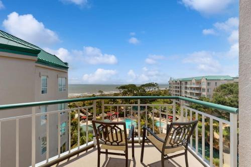 a balcony with two chairs and a view of the beach at Windsor Court North 4504 in Hilton Head Island