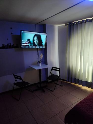 a room with a table and a tv on a wall at Deluxe Miraflores in Miraflores