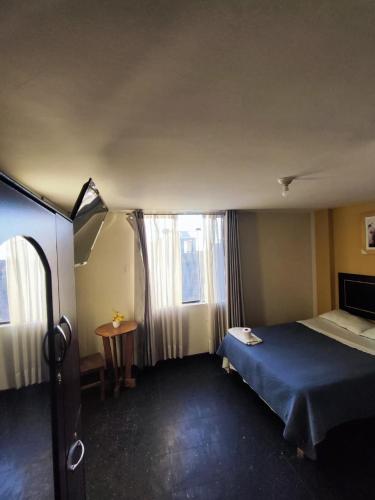 a bedroom with a blue bed and a window at Deluxe Miraflores in Miraflores