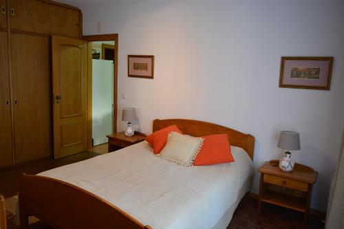- une chambre dotée d'un lit avec des oreillers orange dans l'établissement Apartamento T1 Ericeira, à Ericeira