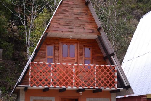 a cabin with a balcony in the woods at Cabañas Cinco Lagos in Santiago