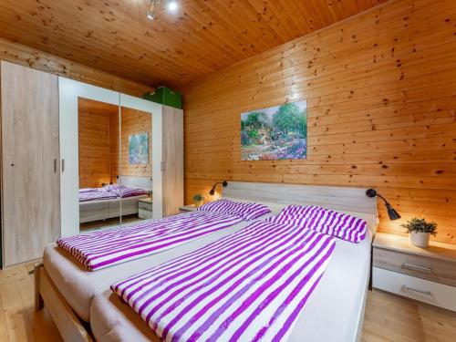 a bedroom with a large bed in a wooden wall at Sternenchalet in Liebenfels
