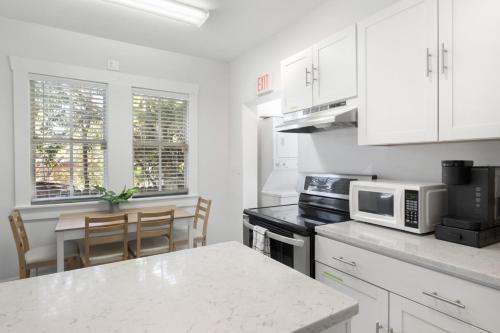 a kitchen with white cabinets and a table with a microwave at Updated 1 BR Home - Steps to 7th Ave in Tampa