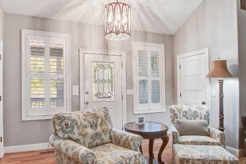 a living room with two chairs and a table and a chandelier at Why Knot? in Edisto Island