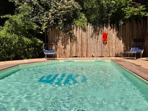 a swimming pool with two chairs and a person jumping into it at WIKI HOSTEL Colive - Adults Only & Pet Friendly in Zagarolo