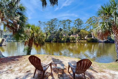 two chairs and a table in front of a lake at Egrets Pointe 491 in Edisto Beach
