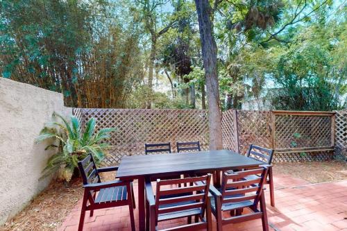 a wooden table and chairs on a patio at Beach Club Bungalow in Hilton Head Island