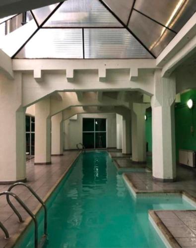 a swimming pool in a building with a large ceiling at Departamento al Canal in Buenos Aires