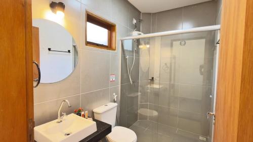 a bathroom with a shower and a toilet and a sink at Pousada Iandara in Pirenópolis