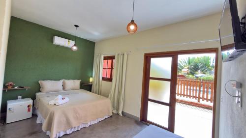 a bedroom with a bed with a green wall at Pousada Iandara in Pirenópolis