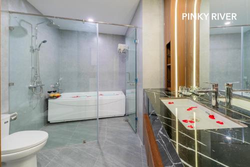 a bathroom with a glass shower and a toilet at PinkyRiver in Danang