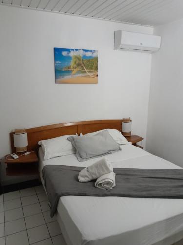 a bedroom with a bed with a towel on it at Appartement MANBANA 320 - accès direct a la plage in Grand-Bourg