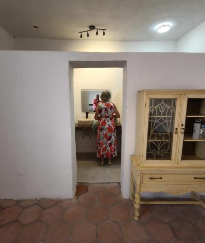 a woman in a dress standing in a mirror at Tu hostalito en Parras in Santa Isabel