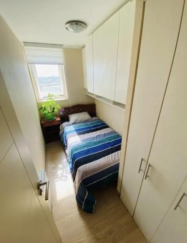 a small room with two beds and a window at Departamento Centro Chillán in Chillán