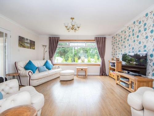 a living room with a couch and a tv at Caledon in Aviemore