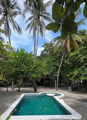 a swimming pool in front of a resort with palm trees at Bluehaven Austin House in La Paz