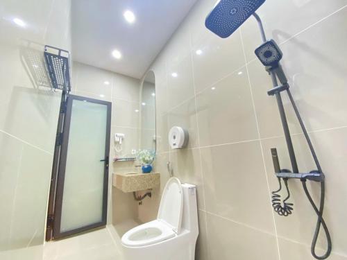 a bathroom with a shower with a toilet and a mirror at Hong My Hotel in Kon Tum (2)