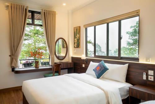 a bedroom with two beds and a large window at Pine Hill Villa Sapa in Sapa