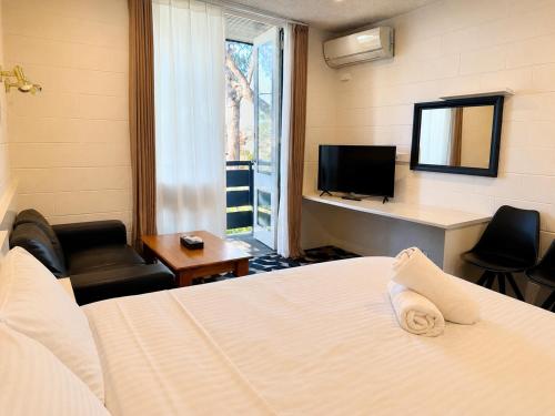 a hotel room with a bed and a television at Pathfinder Motel in Melbourne