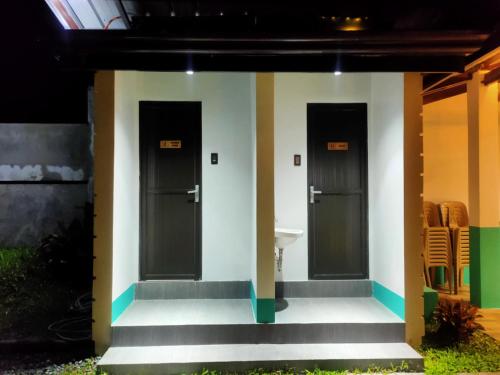a group of three doors on a building with stairs at Kia Ora Villa Staycation in Los Baños