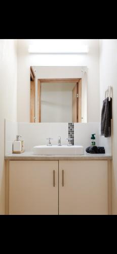a bathroom with a sink and a mirror at Waves & Wildlife Cottages Kangaroo Island in Stokes Bay