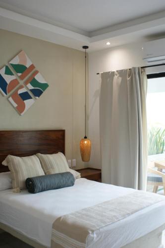 a bedroom with a large white bed and a window at Hotel Boutique Kasa Sara in San Patricio Melaque