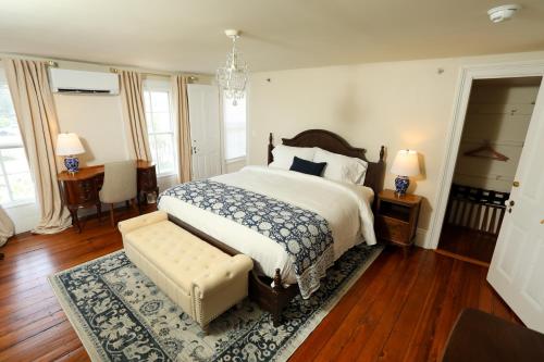 a bedroom with a bed and a bench in it at Cypress River Inn & Spa in Snow Hill