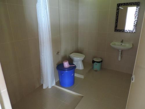 a small bathroom with a toilet and a sink at Riverside Guesthouse in Bukit Lawang