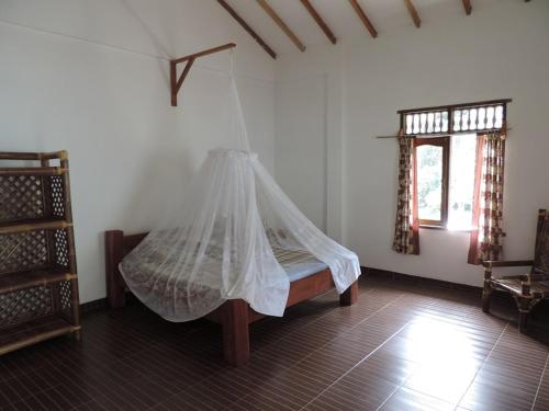 a bedroom with a bed with a mosquito net at Riverside Guesthouse in Bukit Lawang