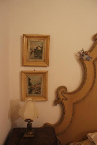 a room with two pictures and a lamp on a table at Agriturismo alle Torricelle in Verona