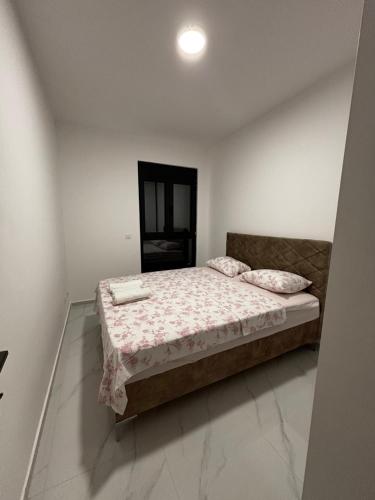a bedroom with a bed in a white room at Apartmani B&A in Ulcinj