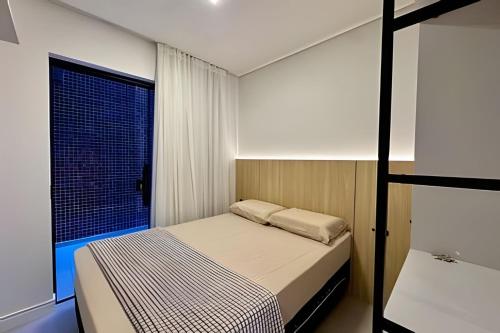 a small bedroom with a bed and a window at Harmonie apto requintado | Centro | 200m do mar in Itapoa